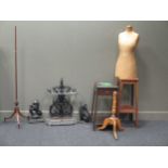 A tailor's dummy, cast iron umbrella stand, 2 doorstops, and a pole screen tripod base