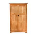 A Yorkshire School sycamore wardrobe in the manner of Peter Waals,