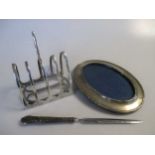 A silver toastrack, 5.1ozt together with a silver photograph frame and a modern paper knife with