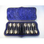 A cased set of 12 silver teaspoons and tongs, a cased pair of silver christening flatware and