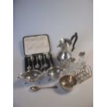 Two silver sauce boats, a silver toast rack, a silver christening bowl and spoon, a silver jug and