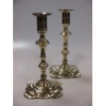 A pair of Queen Anne brass candlesticks with petal bases, 23cm high