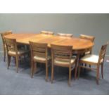 An Art Deco style walnut extending dining table with two leaves together with a set of eight