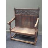 An oak settle with carved frieze panel to back 127 x 99 x 58cm