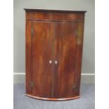 A George III mahogany bow front hanging corner cupboard, 110 x 74cm