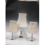 Two similar cut glass and gilt metal mounted table lamps; and another larger similar lamp (3)