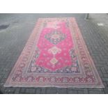 A red ground wool Kelly rug, 402 x 202cm