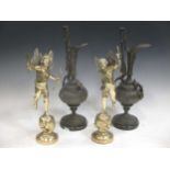 A pair of bronzed ewers together with a pair of brass cherub figures, 37cm high