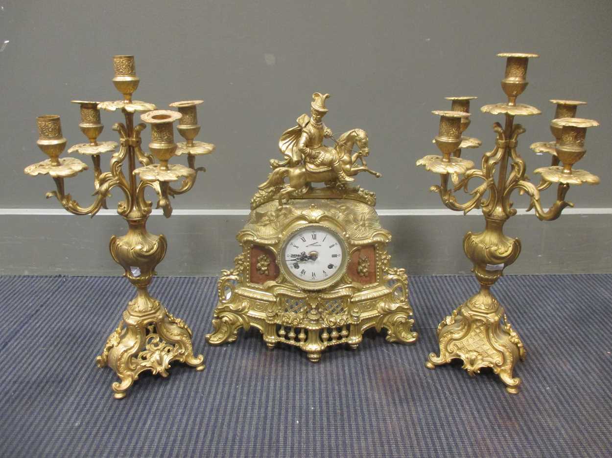 A brass clock garniture, the clock 41cm high, the candelabra 47cm high