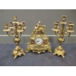 A brass clock garniture, the clock 41cm high, the candelabra 47cm high