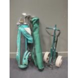 A part set of modern golf clubs and accessories, including a trolley