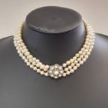 A three row pearl collar with a diamond set clasp,