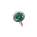 An emerald and diamond halo style cluster ring,