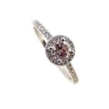 A pink and white diamond halo cluster ring,