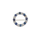 A Swedish metalwares 18ct circle brooch set with sapphires and diamonds,