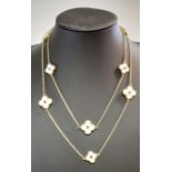 A chain necklace of mother of pearl set quatrefoil flowers,