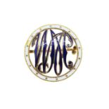 A circular enamelled monogram brooch,