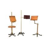 A group of three Edwardian mahogany and brass adjustable reading stands,