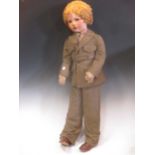 A large near life size painted felt head doll c.1940s, curly blonde wig, khaki uniform, some old