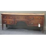 An George III elm kneehole dresser with five drawers surrounding an arch on tappered legs 82 x 205 x