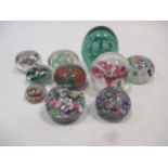 A collection of ten glass dump paper weights, some with cane work, including one bearing Vasart