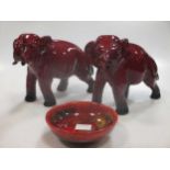 Two Royal Doulton flambe elephants, signed 'FM' (Fred Moore) and a small Royal Doulton flambe saucer