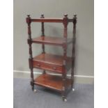 An early Victorian mahogany four tier whatnot with single drawer and turned supports on white