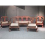 An early 20th century Chinese hardwood salon suite, with four armchairs and a three seater settee