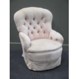 A late 19th century buttoned back chair with turned front legs and castors