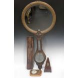 An aneroid barometer, another barometer, a metronome, a wood carving of Christ and a pine oval