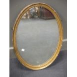 A George III style oval carved gilt wood wall mirror, 67 x 46cm