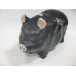 An Alexander Backer Co. painted black pig money box, 42cm long