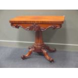 A William IV mahogany card table on chamfered column and acanthus leaf carved scroll legs on white
