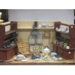 A dolls kitchen in a scratch built shaped case with a tin plate Mfz range, two dressers, a table,