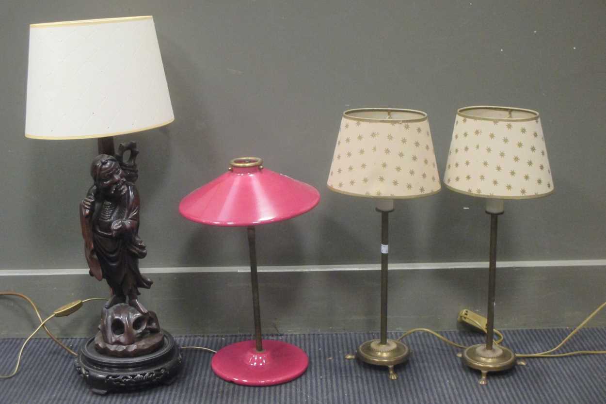 A Chinese carved wood figure adapted into a lamp base together with a French lamp and a pair of