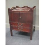 A large George III mahognay 'tray top' bedside cabinet/commode, the two doors above a pull out base,