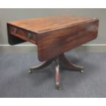 A late Georgian mahogany drop leaf breakfast table on turned column on four outswept legs with brass
