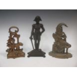 A Lord Nelson cast iron doorstop and two others - a walking lion with gilt finish and a brass Mr