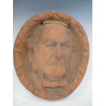 A terracotta oval wall plaque sculpted with the profile of William Gladstone on commemoration of his