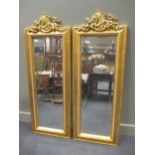 A pair of italian style giltwood pier mirrors with putti cresting and bevelled plates 143 x 52cm