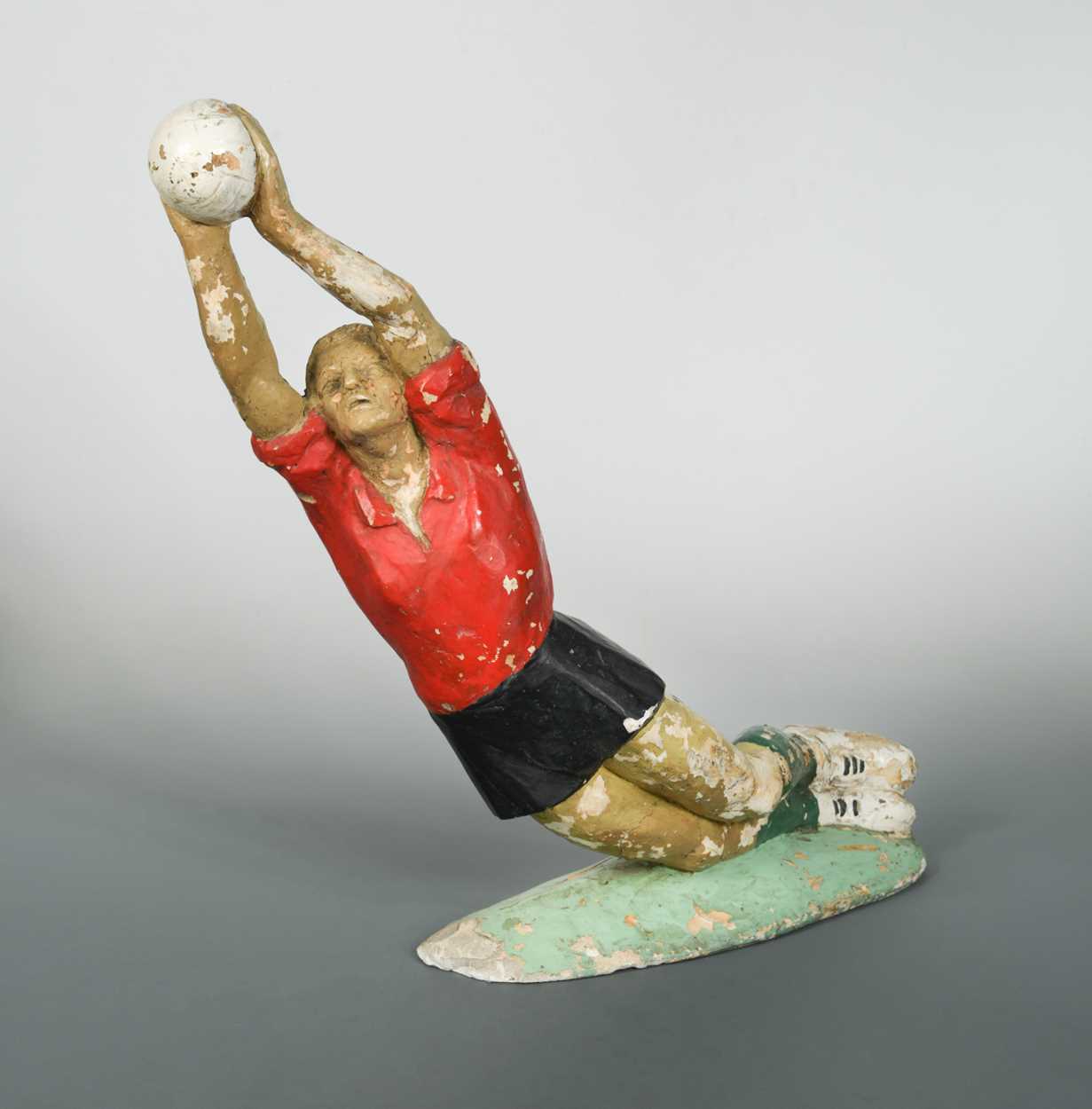 A mid-century plaster figure of a footballer,