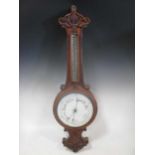 A carved oak aneroid barometer, 82cm high