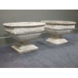 A pair of square garden planters with floral relief decoration on stepped square pedestal bases 44 x