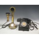 A vintage bakelite telephone together with a reproduction brass telephone