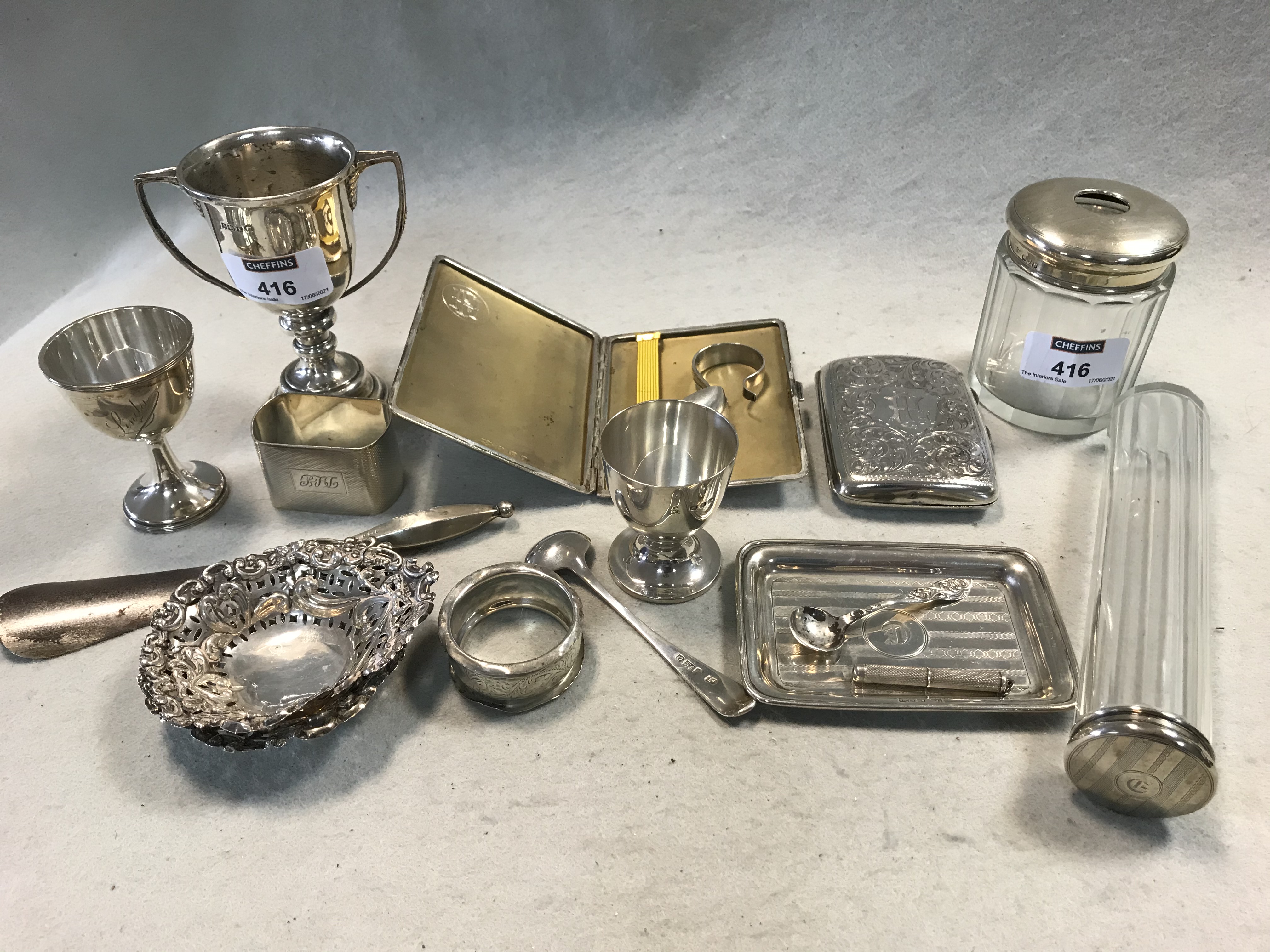 A collection of silverware including pin trays, egg cups, napkin ring, flatware, dressing table