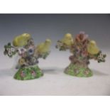 A pair of Stafforshire spill vases, set with a pair of canaries either side of a flowering tree