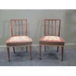 A pair of Georgian, possibly fruitwood, stick back dining chairs with square tapered legs on spade