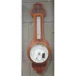 An Edwardian carved oak aneroid barometer