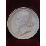 A circular plaster relief plaque of a bearded man in profile, to sinister, signed, 50cms