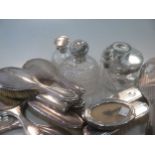 A collection of silverware including silver backed dressing table items, silver topped glass perfume